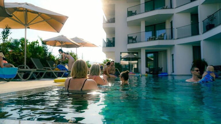 familotel sonnenpark - People enjoying a relaxing day at a hotel swimming pool with sun umbrellas an